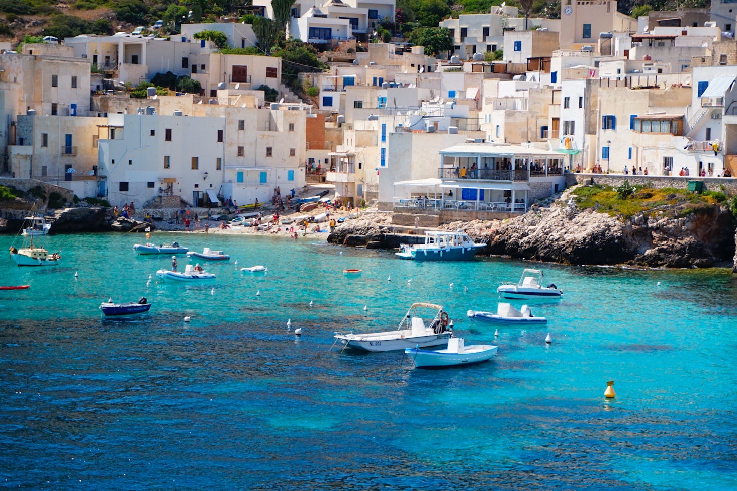 Vista dall'alto sul mare cristallino di Trapani, con spiaggia circondata da case bianche