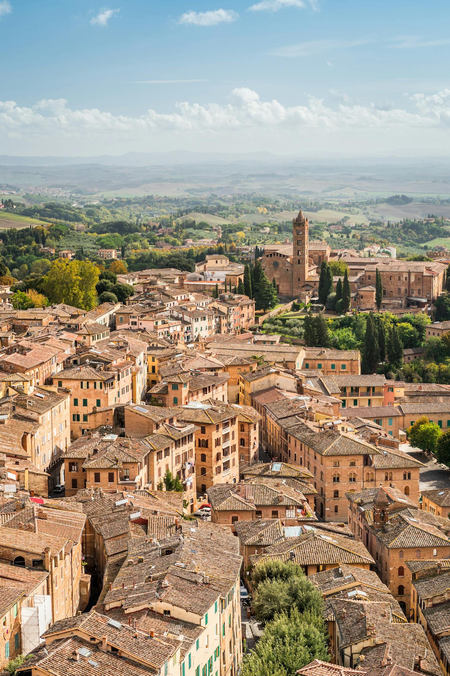 Picturesque Siena, Italy, with stone buildings is surrounded by greenery and hills