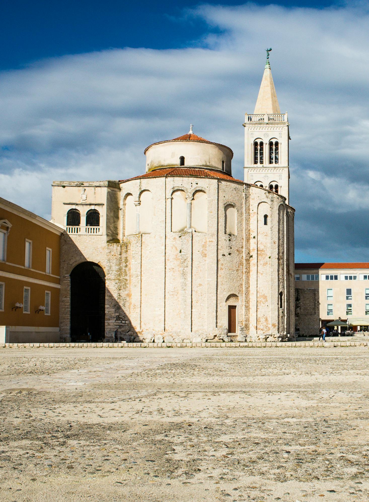 An ancient building in Zadar is beige stone against a blue sky