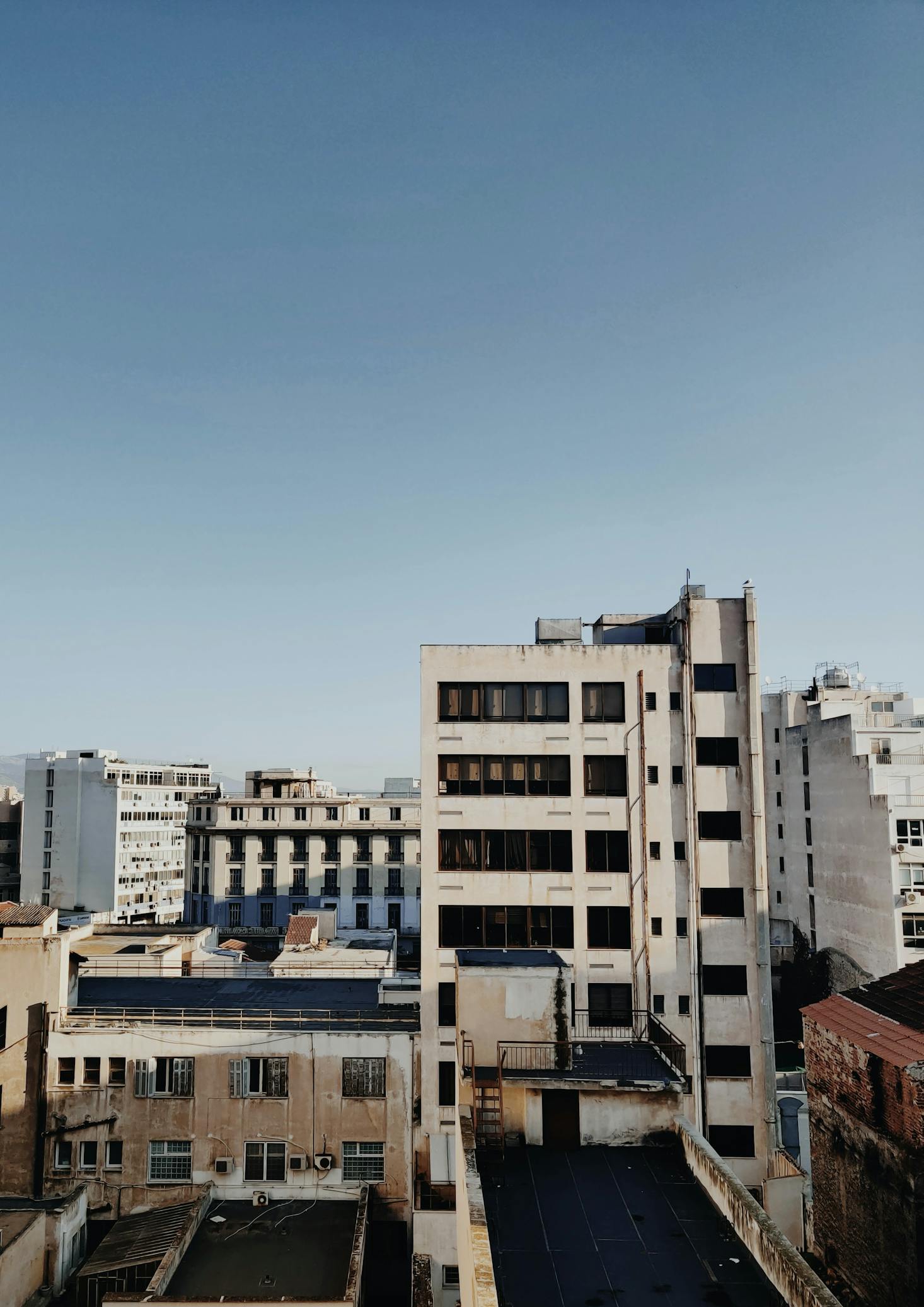 Tall buildings against a blue sky in Piraeus, Greece