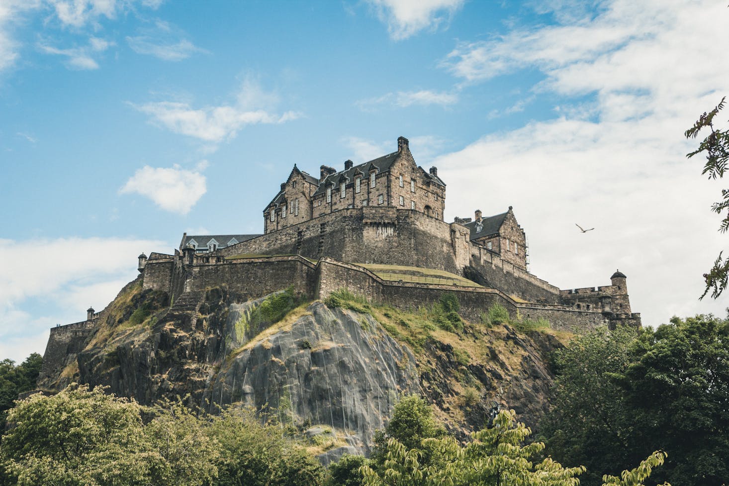 Edinburgh Castle perched atop a hill in Scotland on a sunny day