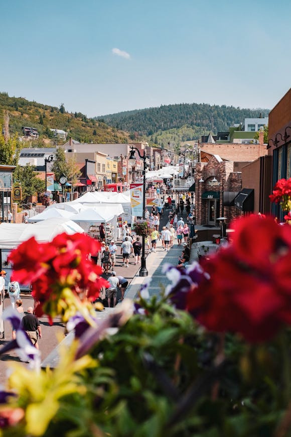 A busy street in a beautiful city filled with shopping stalls and people