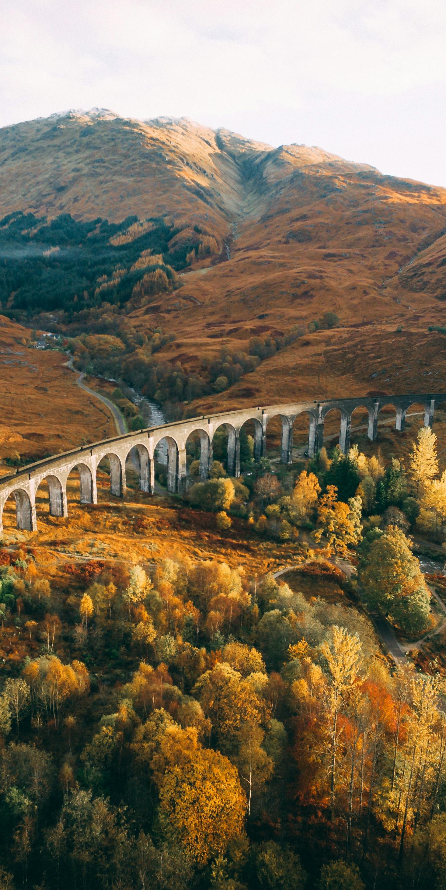 The aqua duct train bridge over a golden field in Fort William, Scotland