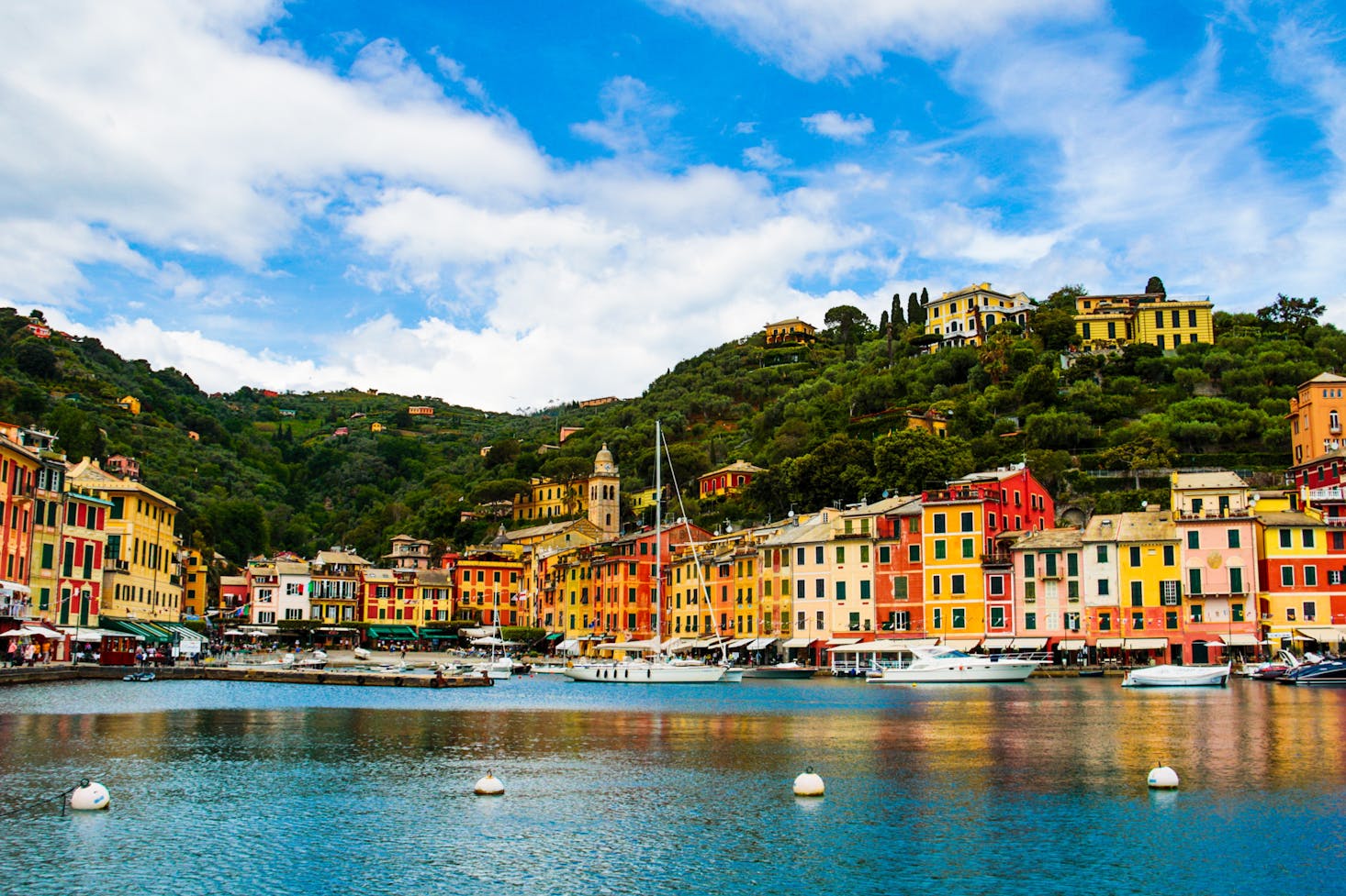 Vista dal mare sul litorale genovese, con case colorate, palazzi e montagne alle spalle