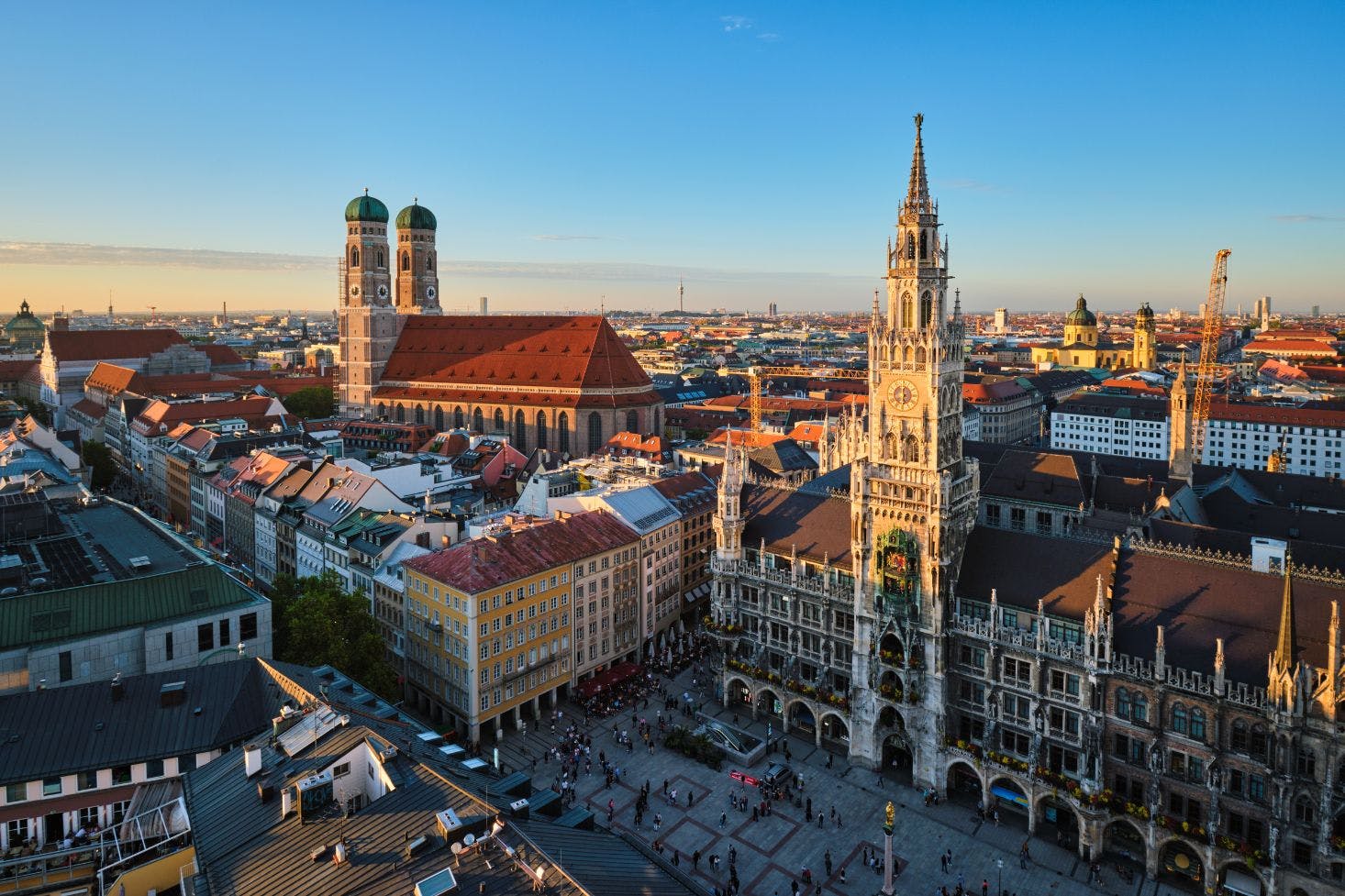 Aerial view of Munich's Marienplatz featuring the Frauenkirche's twin domes, New Town Hall, and the busy square