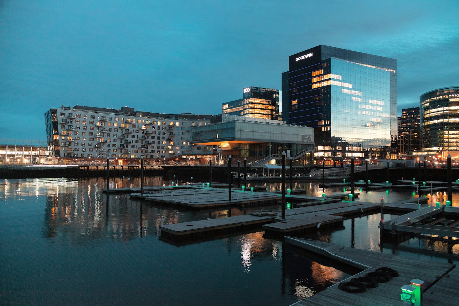 The Boston harbor at night with docks and modern buildings