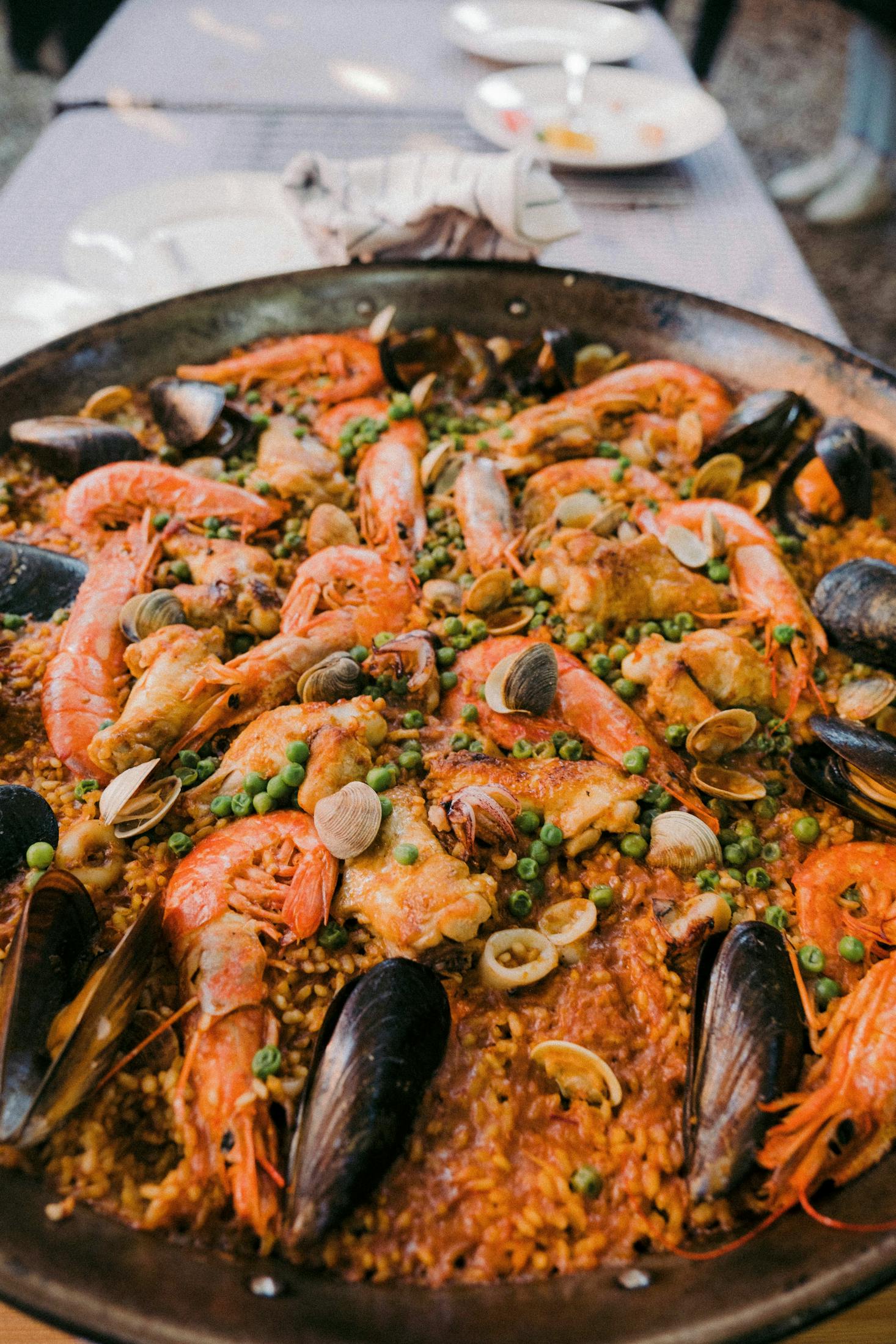  A large platter of paella on a white table