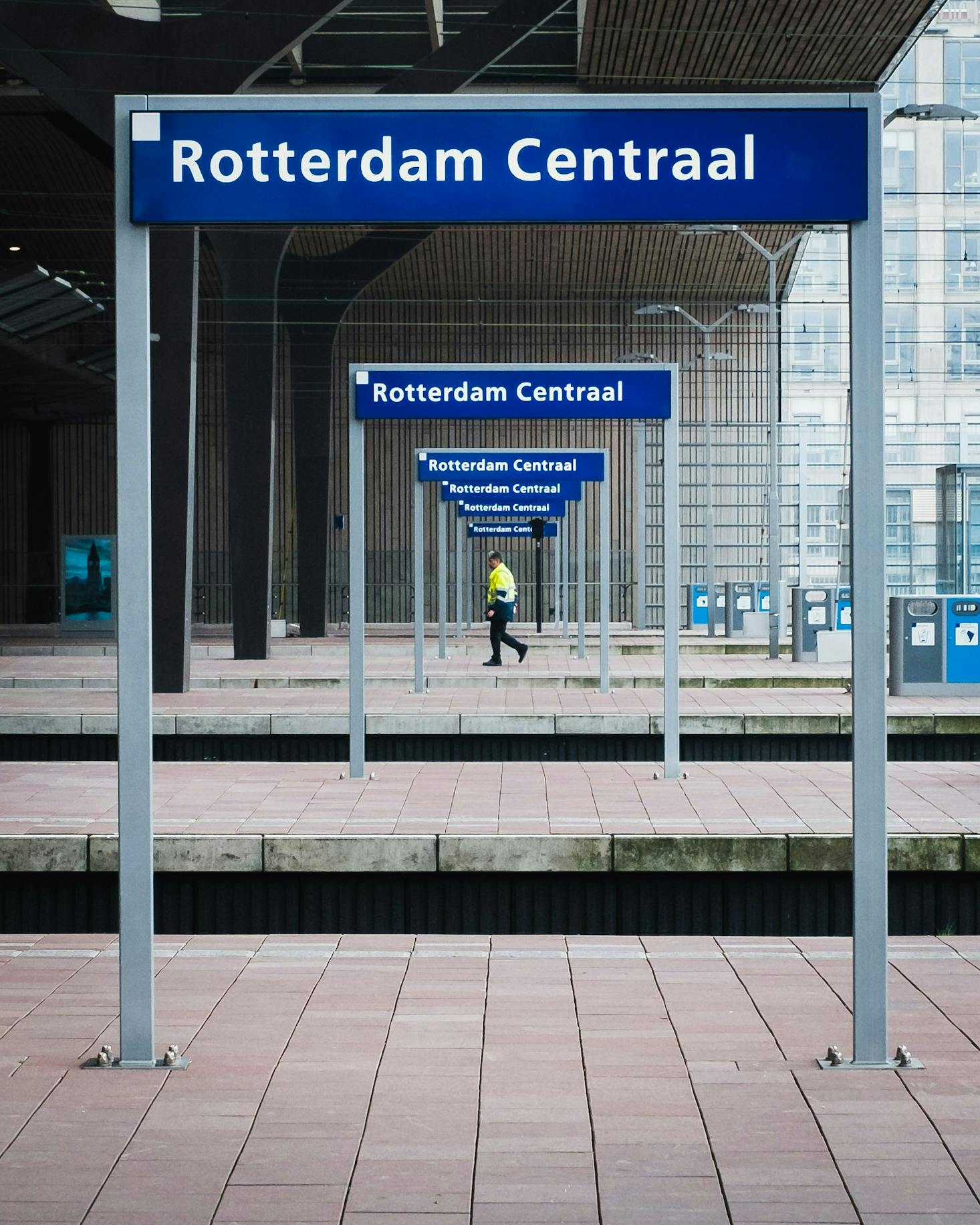 Agent de sécurité sous des panneaux bleu à Rotterdam, Pays-Bas