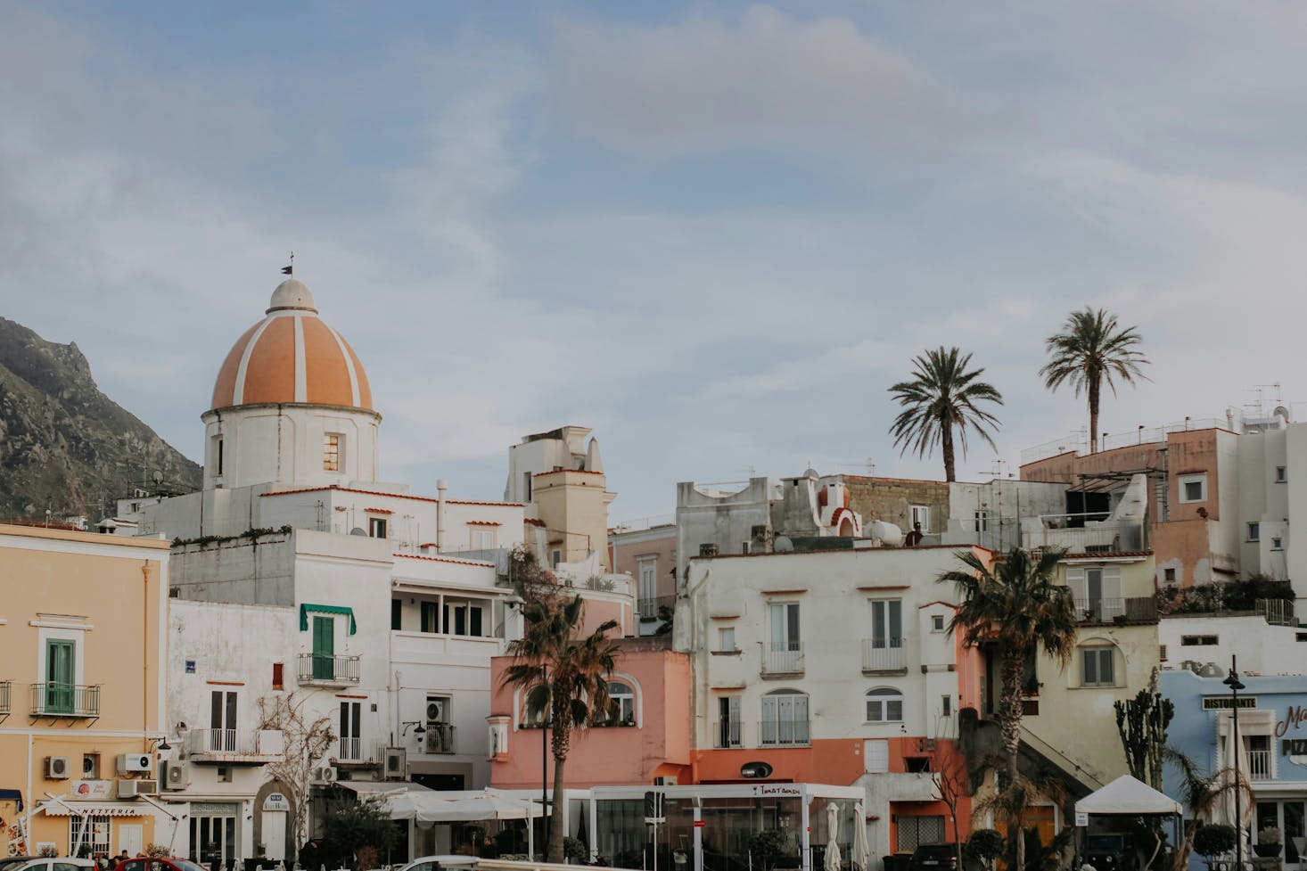 Edifici bianchi e cupola della città di Forio, a Ischia, con cielo azzurro sullo sfondo