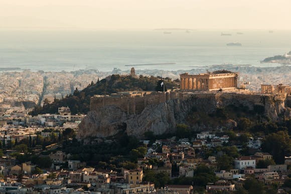 Athens cityscape with views of hills, the sea, the Acropolis, and buildings stretching across the landscape