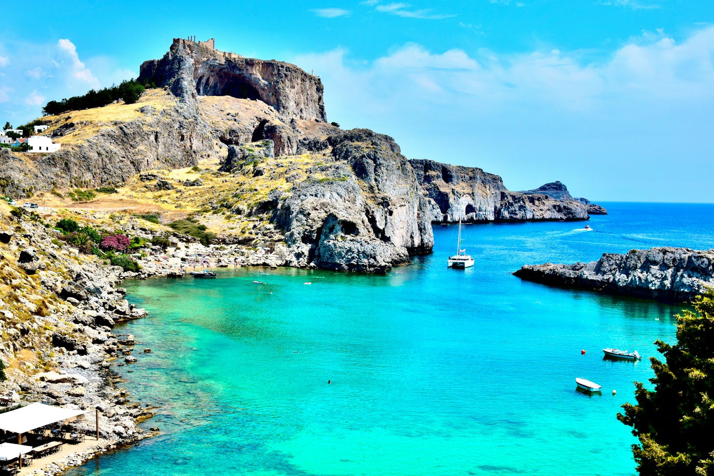 Mare cristallino e costa rocciosa a Rodi, Grecia, con cielo azzurro sullo sfondo