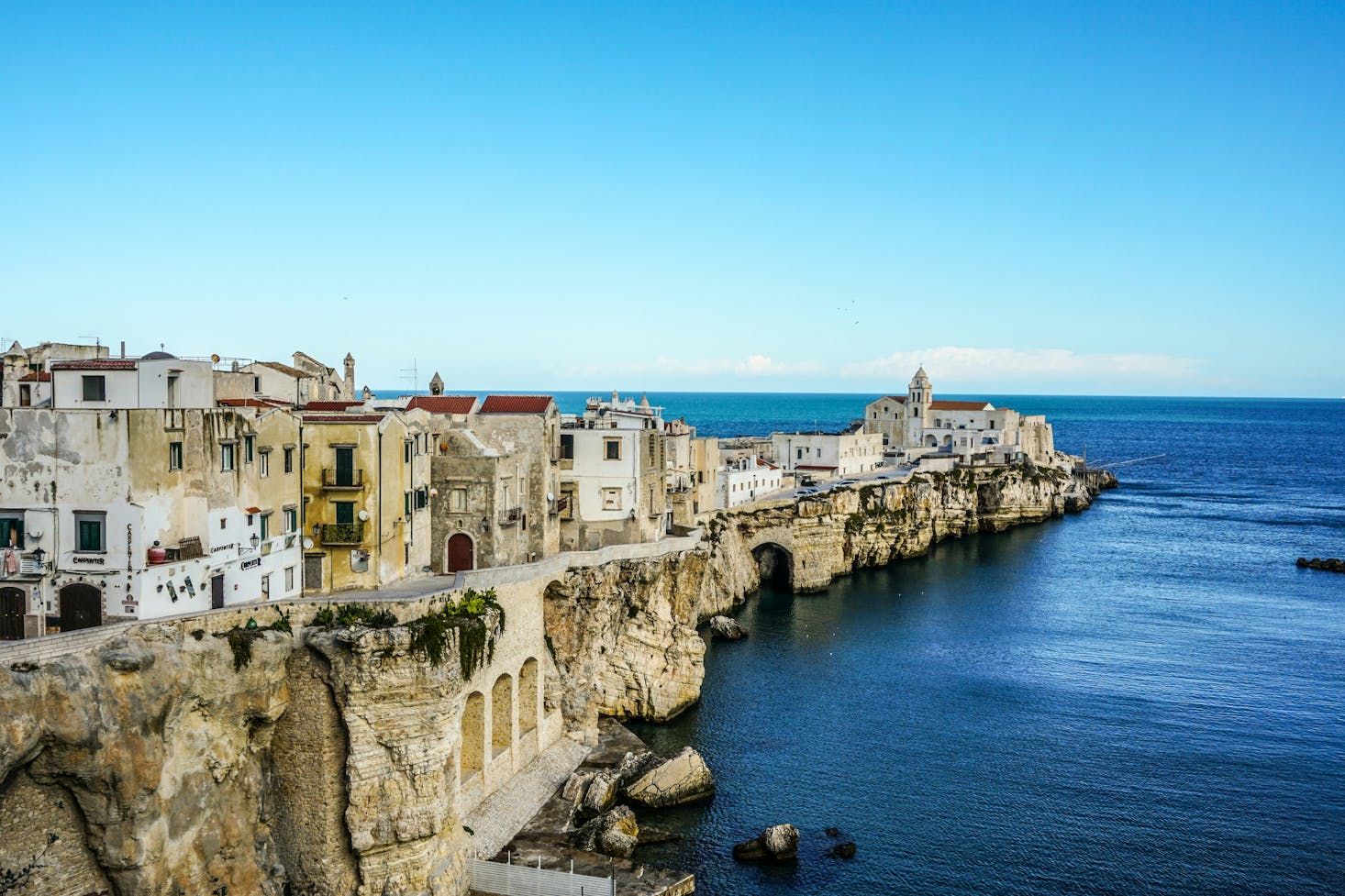 Casette arroccate su lembo di terra roccioso che si protrae nel mare a Foggia, Puglia