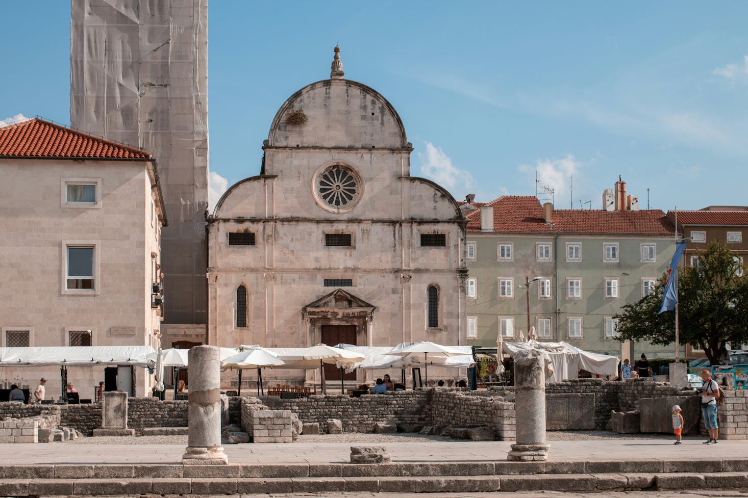 Piazza a Zara, con chiesa, campanile ed edifici caratteristici, e cielo azzurro sullo sfondo