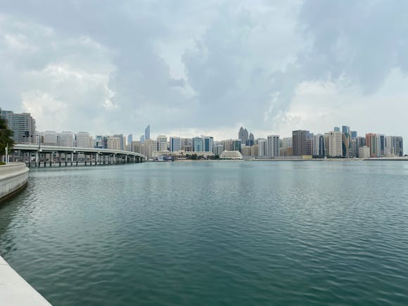 The tall buildings of Abu Dhabi across the water on a cloudy day