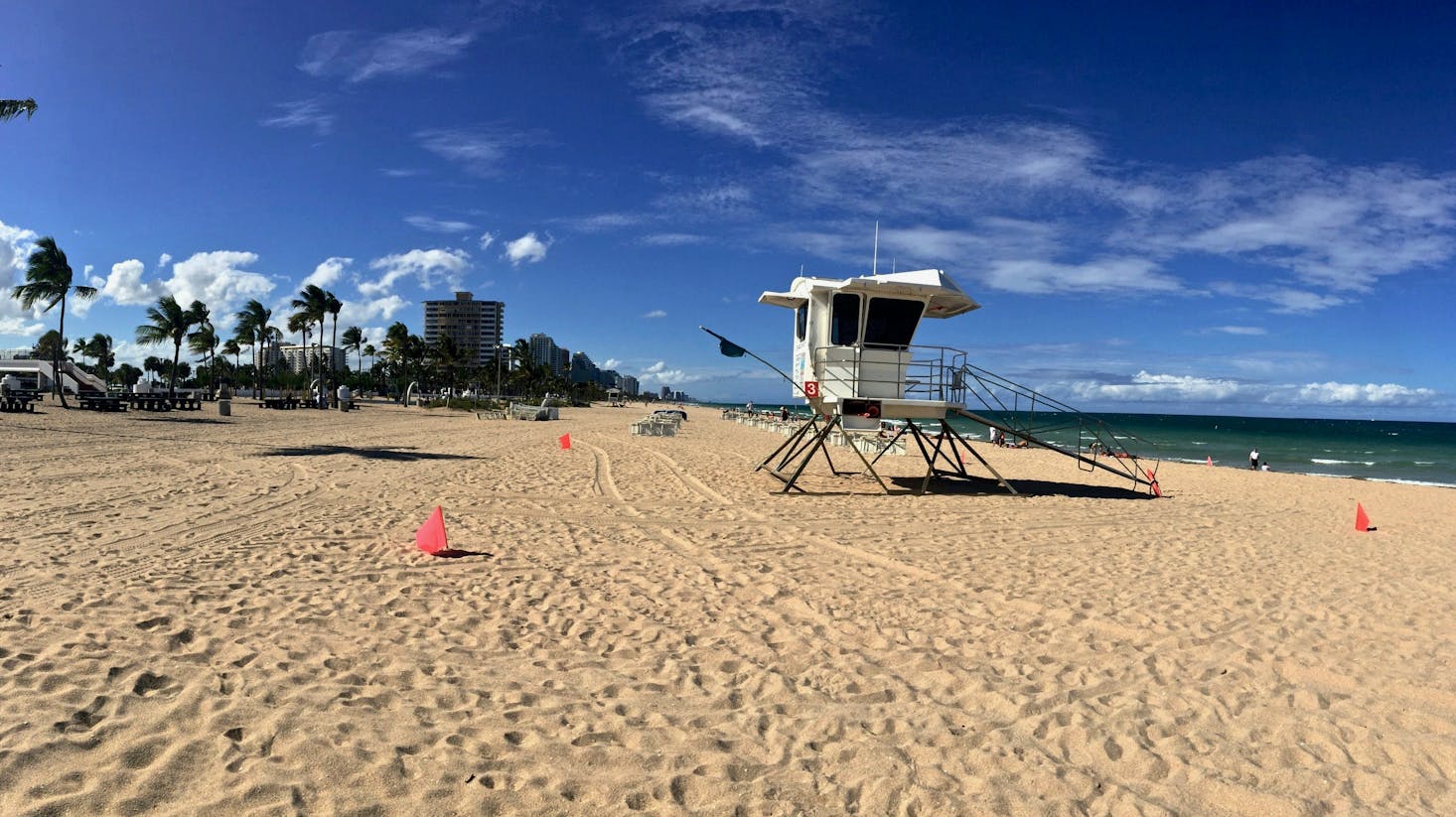 Golden sands of a Fort Lauderdale beach with a lifeguard tower and blue skies 