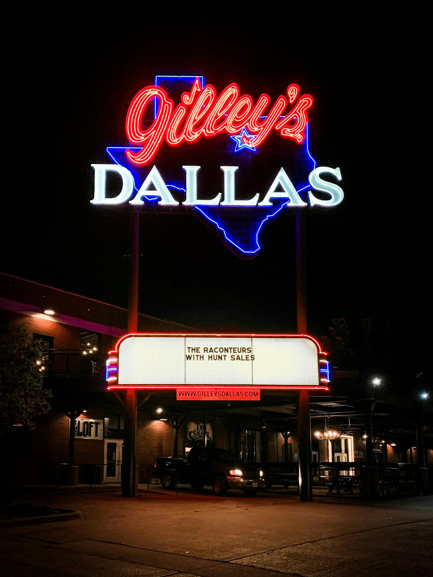 Gilley's Dallas live music venue lit up with neon lights and a marquee