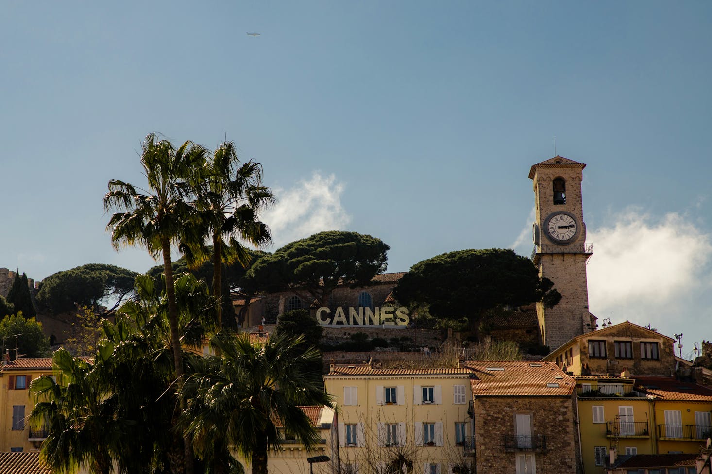 Iconica scritta della città a Cannes, circondata da edifici, verde degli alberi e cielo azzurro sullo sfondo