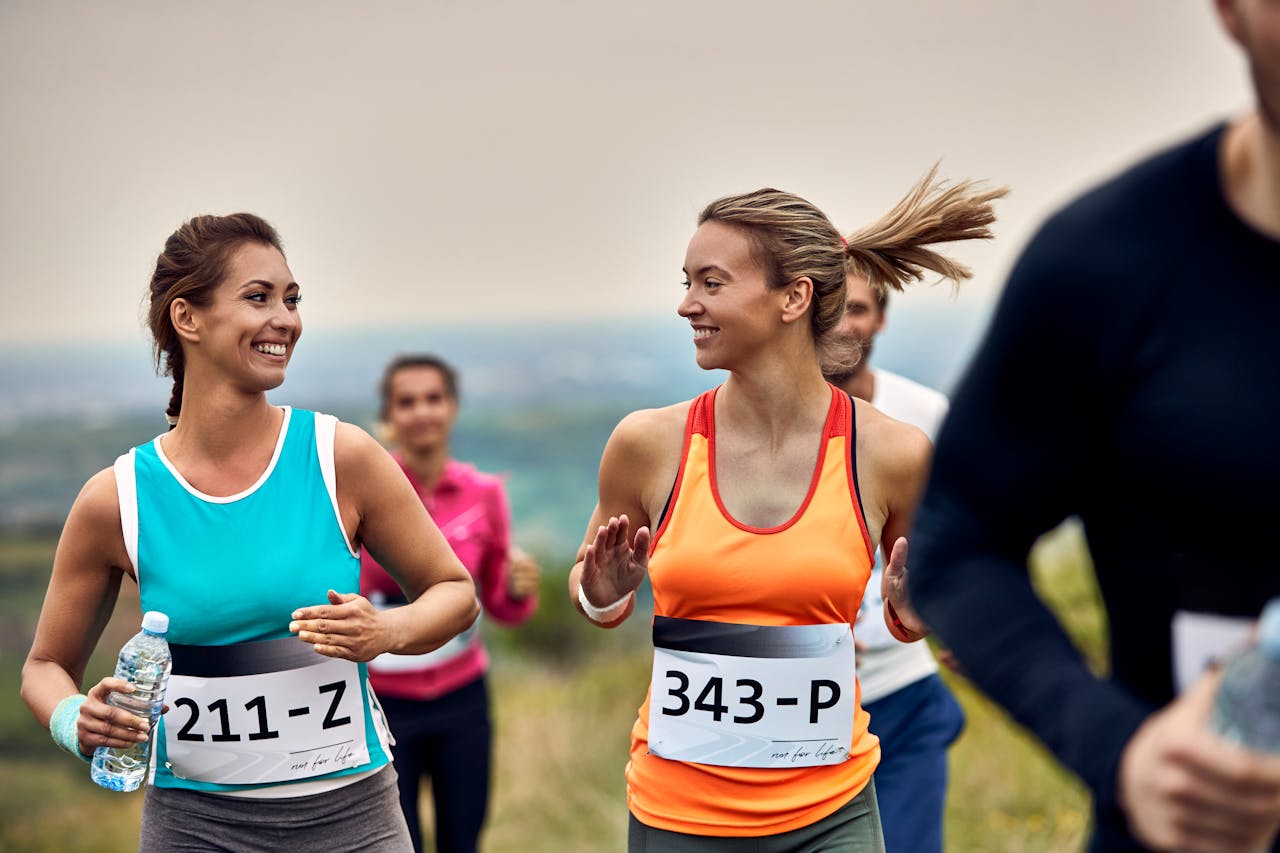 Smiling runners with race bibs enjoying the outdoor course during a marathon