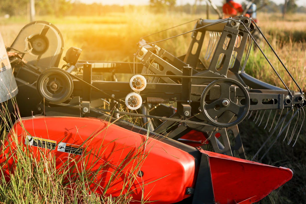 Close-up of modern red and black agricultural machinery in a sunlit field, showcasing advanced farming equipment 