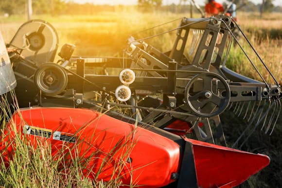 Close-up of modern red and black agricultural machinery in a sunlit field, showcasing advanced farming equipment 