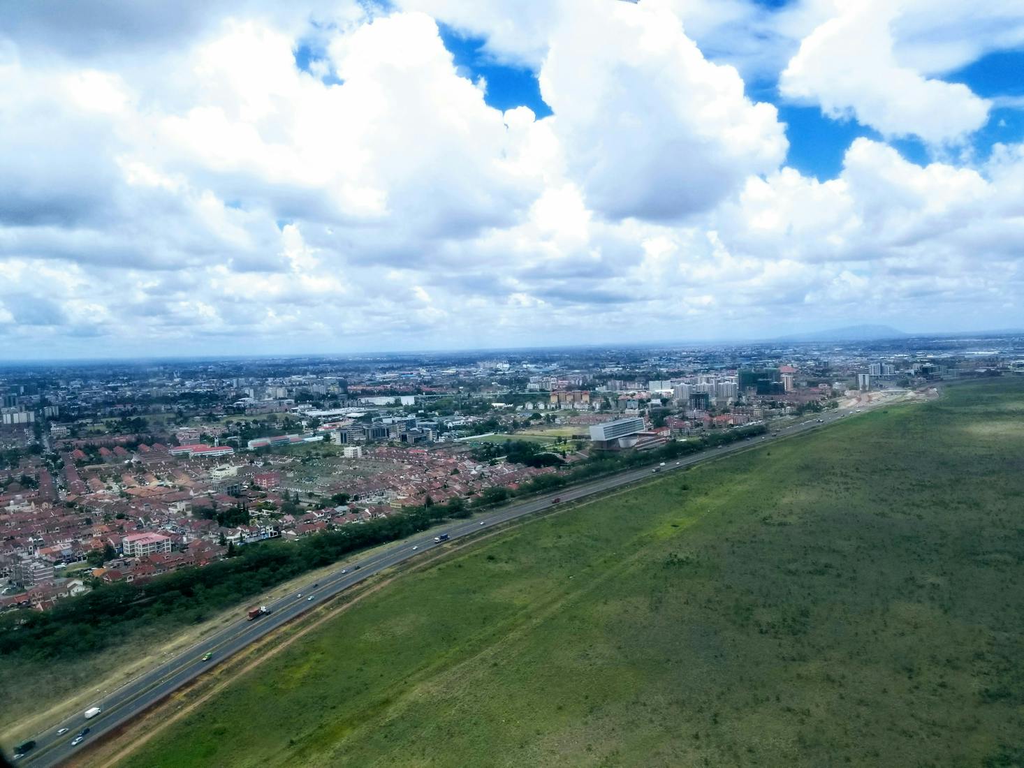 Aerial view of Nairobi Airport with a green field and the city beyond