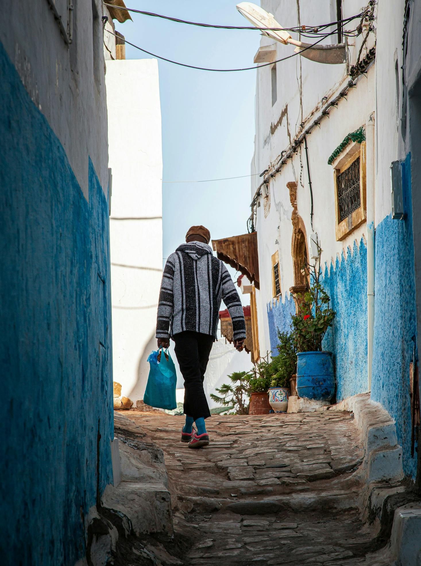 A person walking through the narrow alleyways of Casablanca during the day