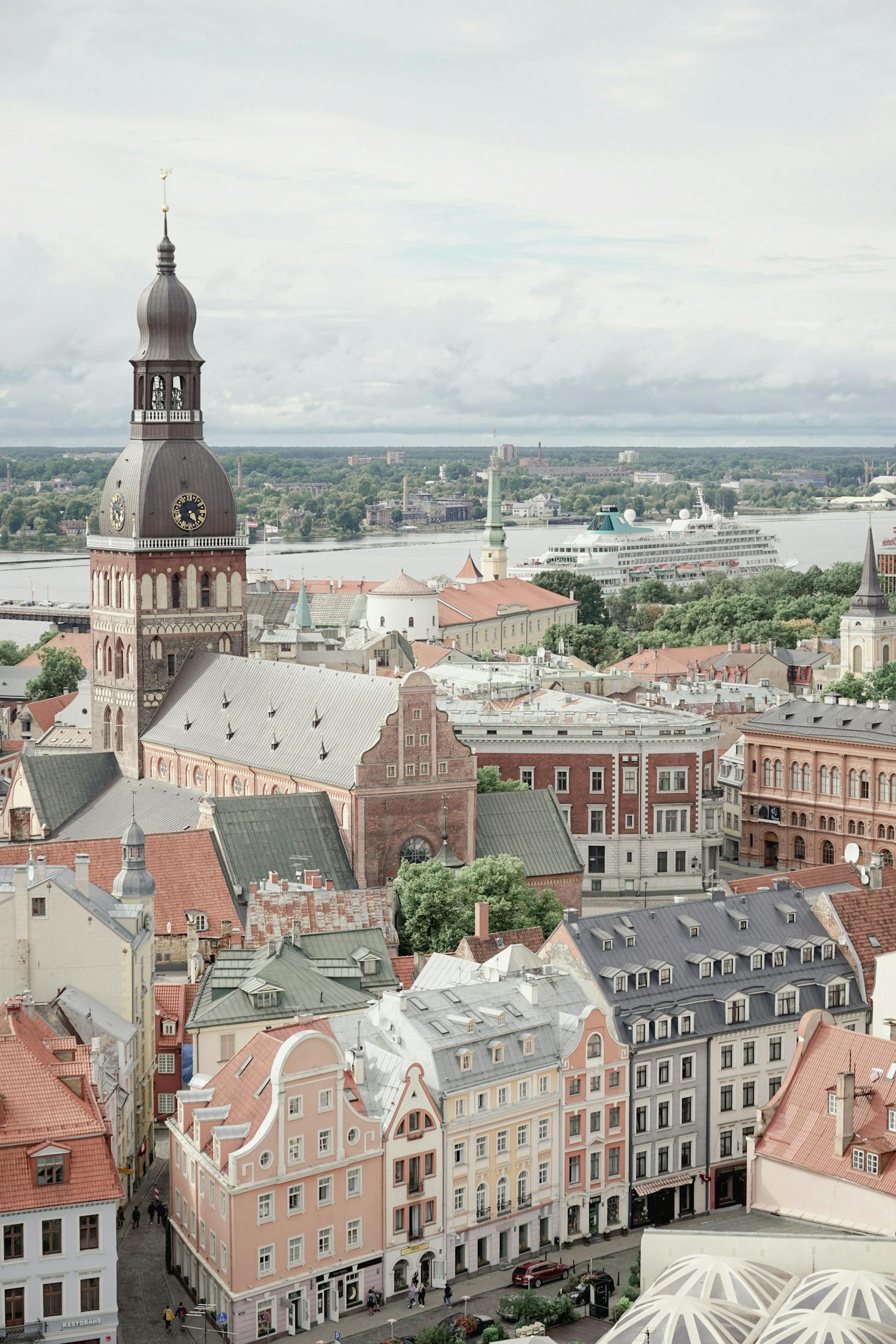 Historic and colorful buildings in Riga with a cruise ship docked in the distance