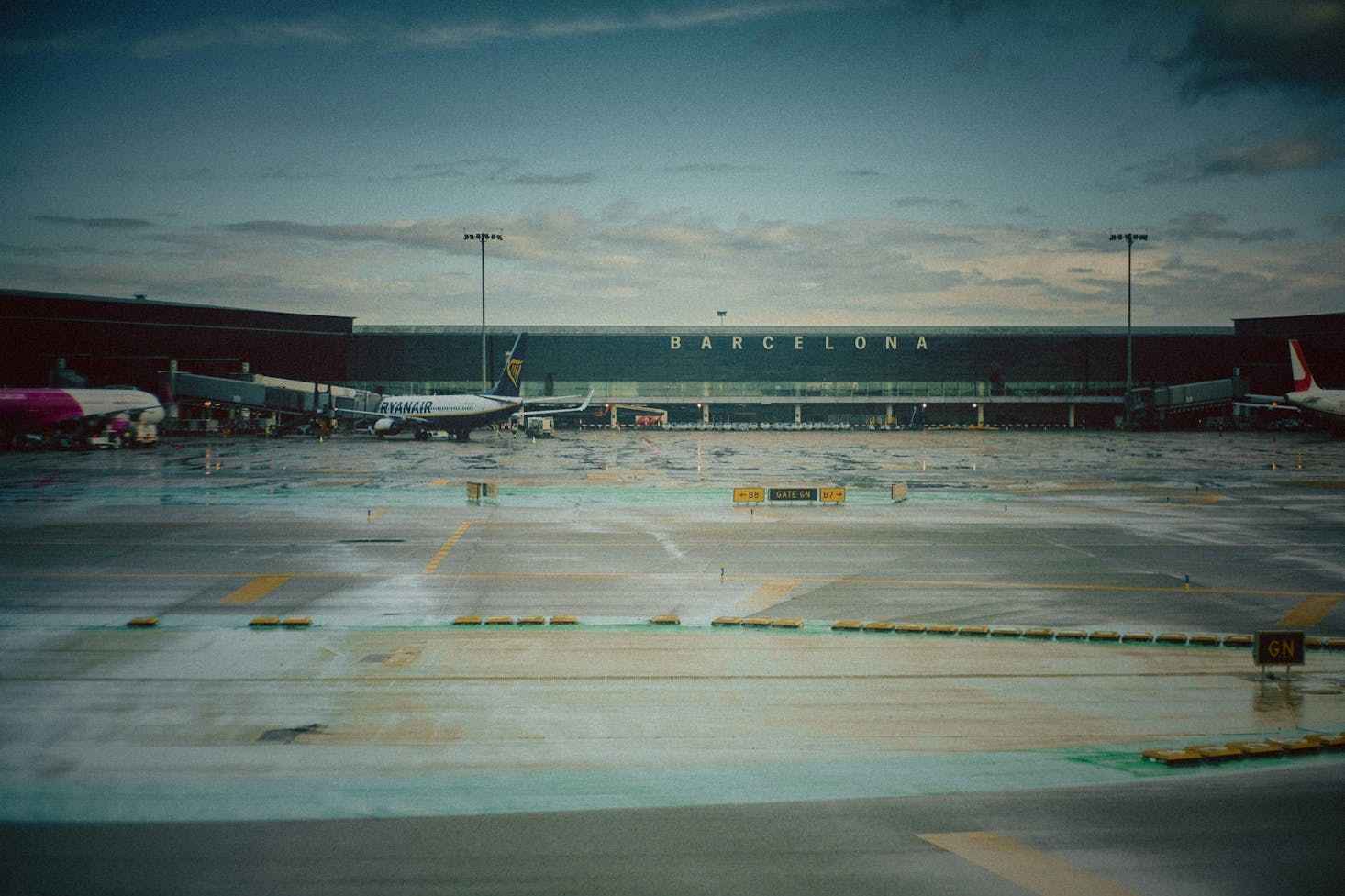 Piazzale dell'Aeroporto di Barcellona, con aereo Ryanair parcheggiato e cielo sereno sullo sfondo