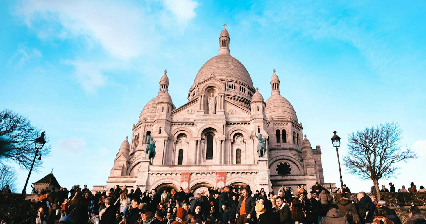 Basilica del Sacro Cuore a Montmartre, molte persone in primo piano e cielo azzurro sullo sfondo