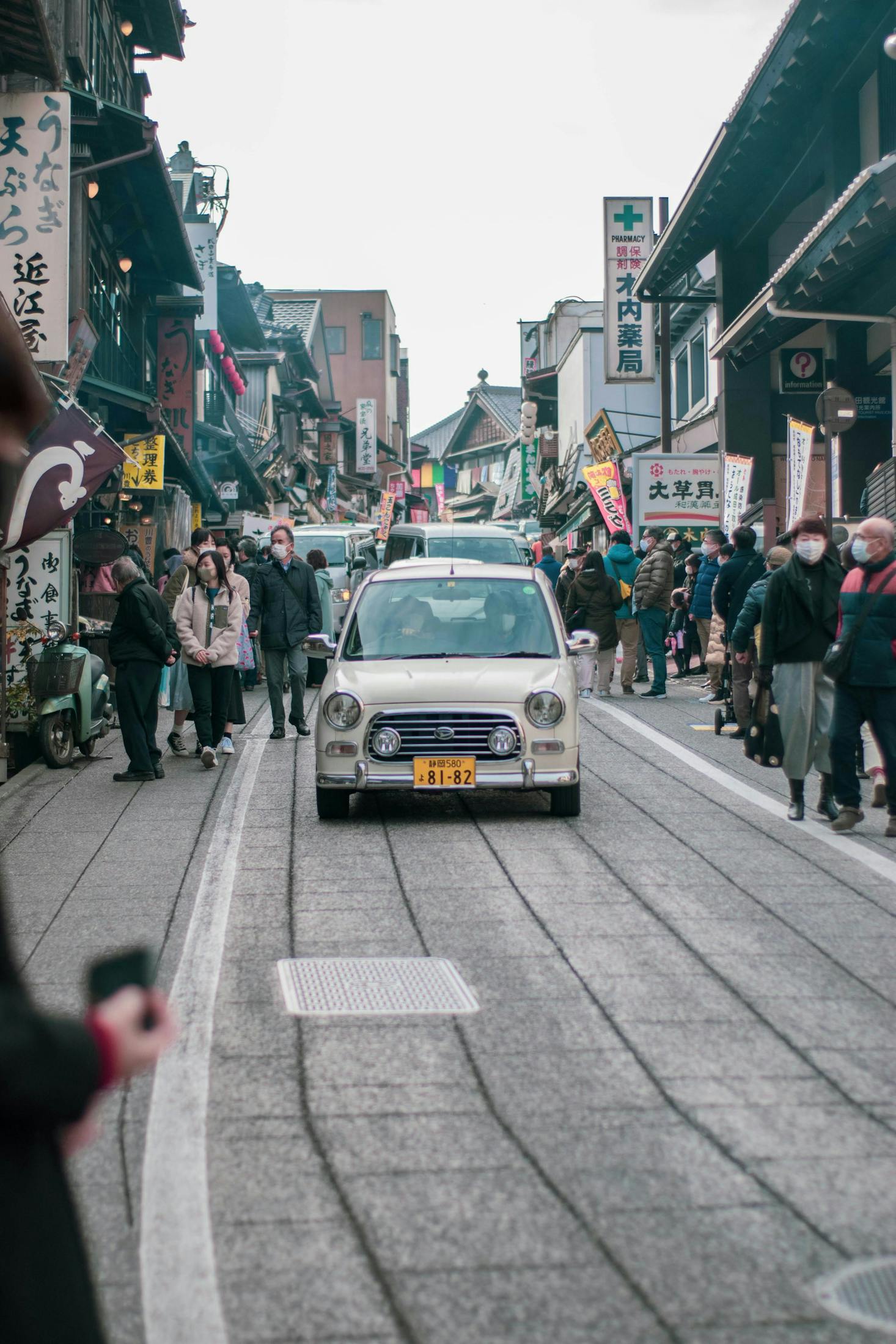 A busy road with cars and pedestrians near Chiba Station