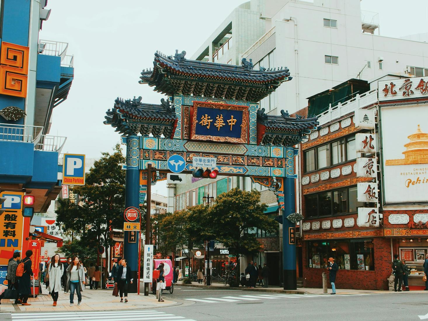 An ornate blue gate at the entrance to Yokohama Chinatown on a cloudy day