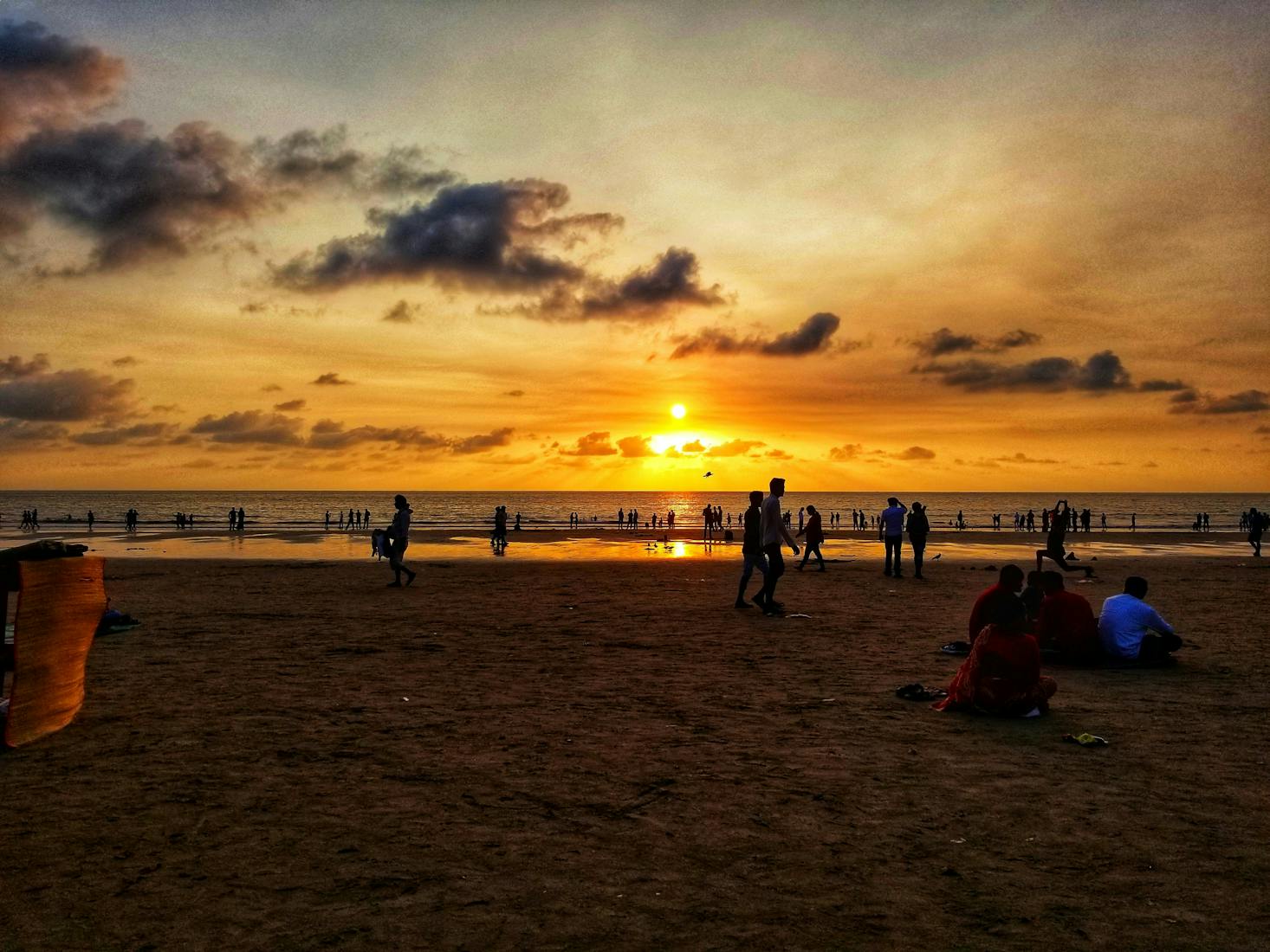 People on the beach at sunset in Mumbai