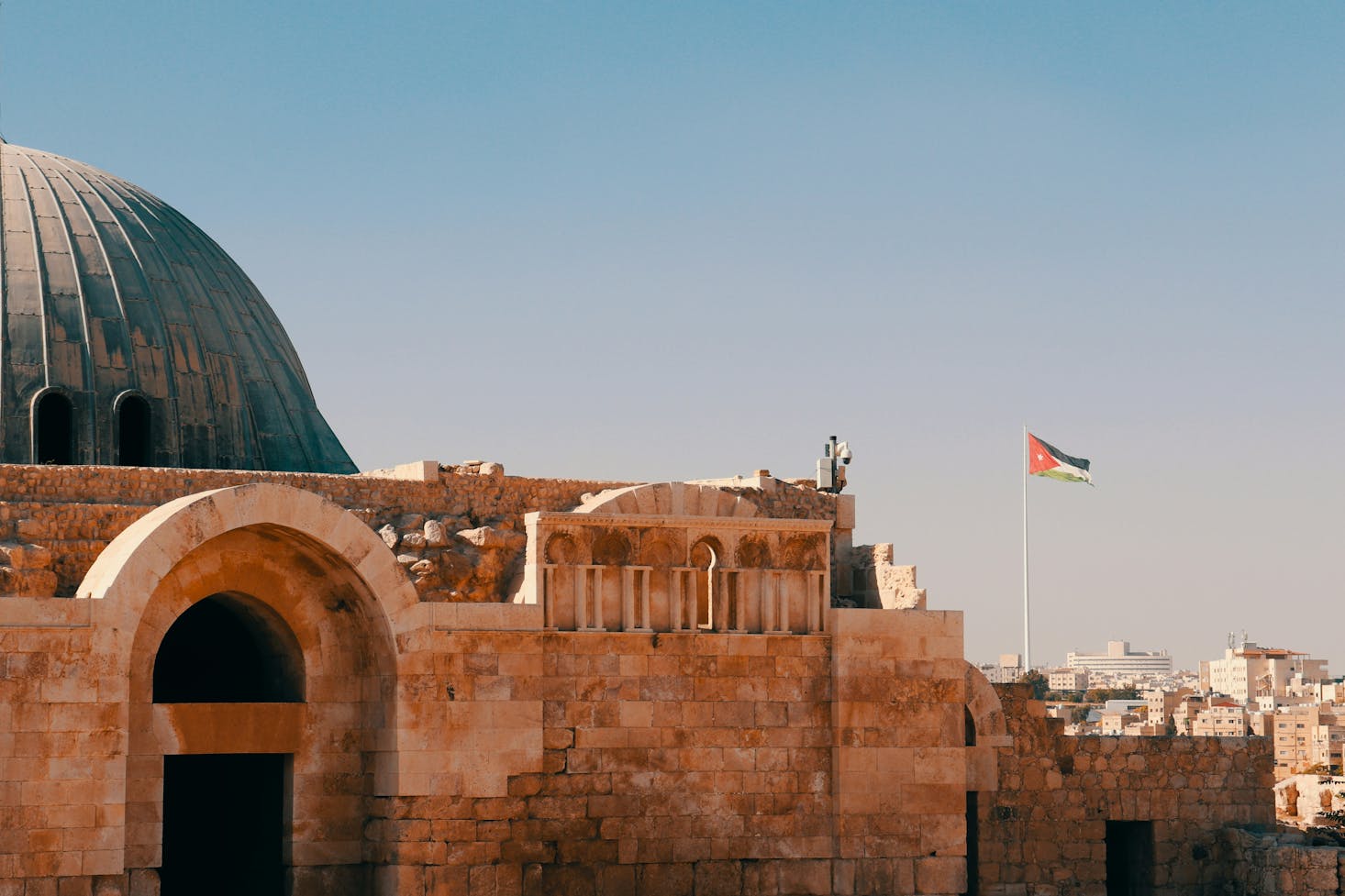 The Dome of the Rock Mosque in Amman with a flag in the distance