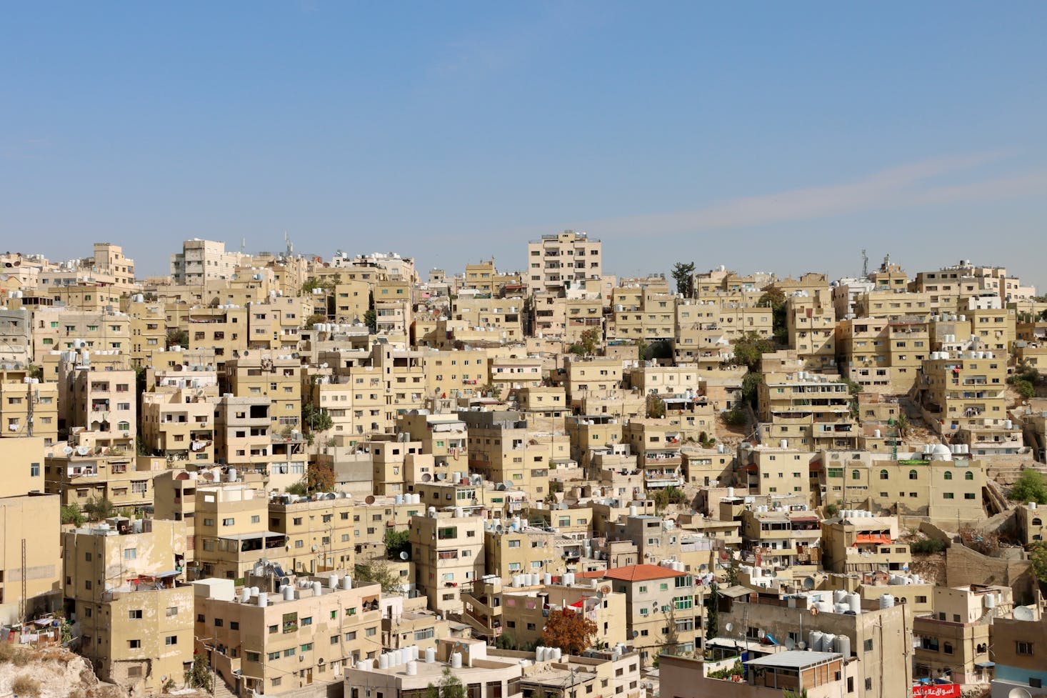 View from the Citadel in Amman of uniform light brown apartment buildings and blue sky