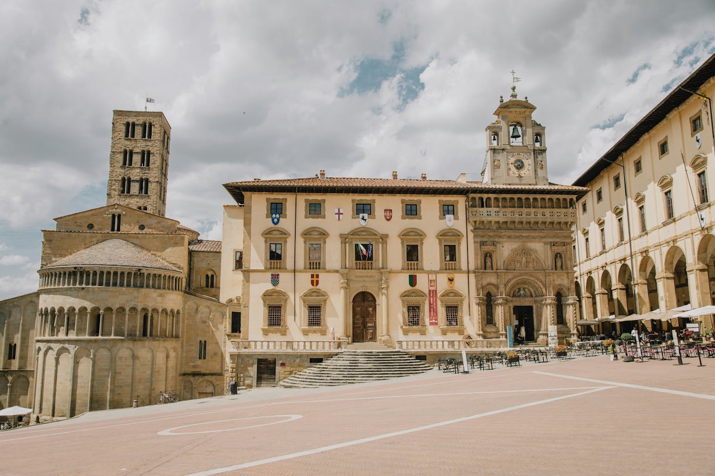 Piazza con chiesa in centro a Arezzo, con cielo nuvoloso sullo sfondo