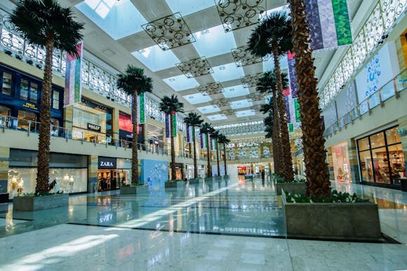 Shopping mall interior in Dubai with hallway lined with tall trees and interesting modern design elements