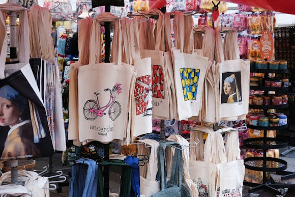 Tote bags with Dutch staples like bikes, tulips, windmills and Vermeer's Girl with other souvenirs on the street stall in Amsterdam