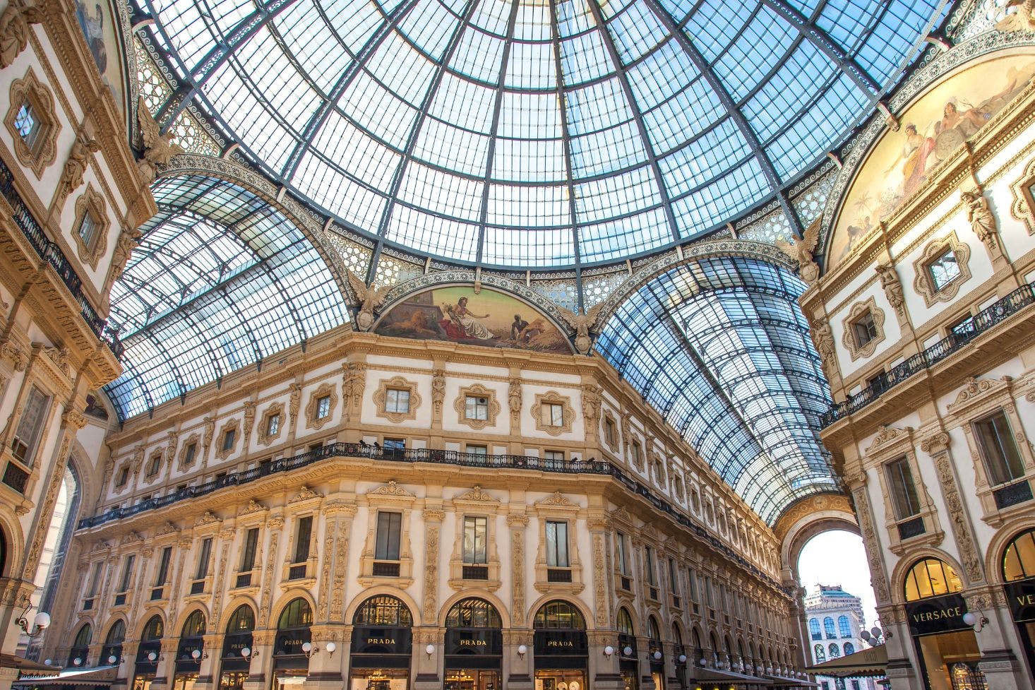 Shops like Prada and Versace in Galleria Vittorio Emanuele II, Milan and the glass dome above