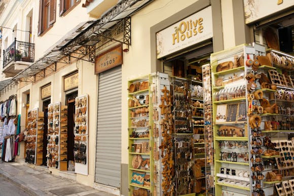 Souvenir shops in Athens, Greece, with sandals, keychains, jewelry, sunglasses, knives, Orthodox crosses, and wooden trays