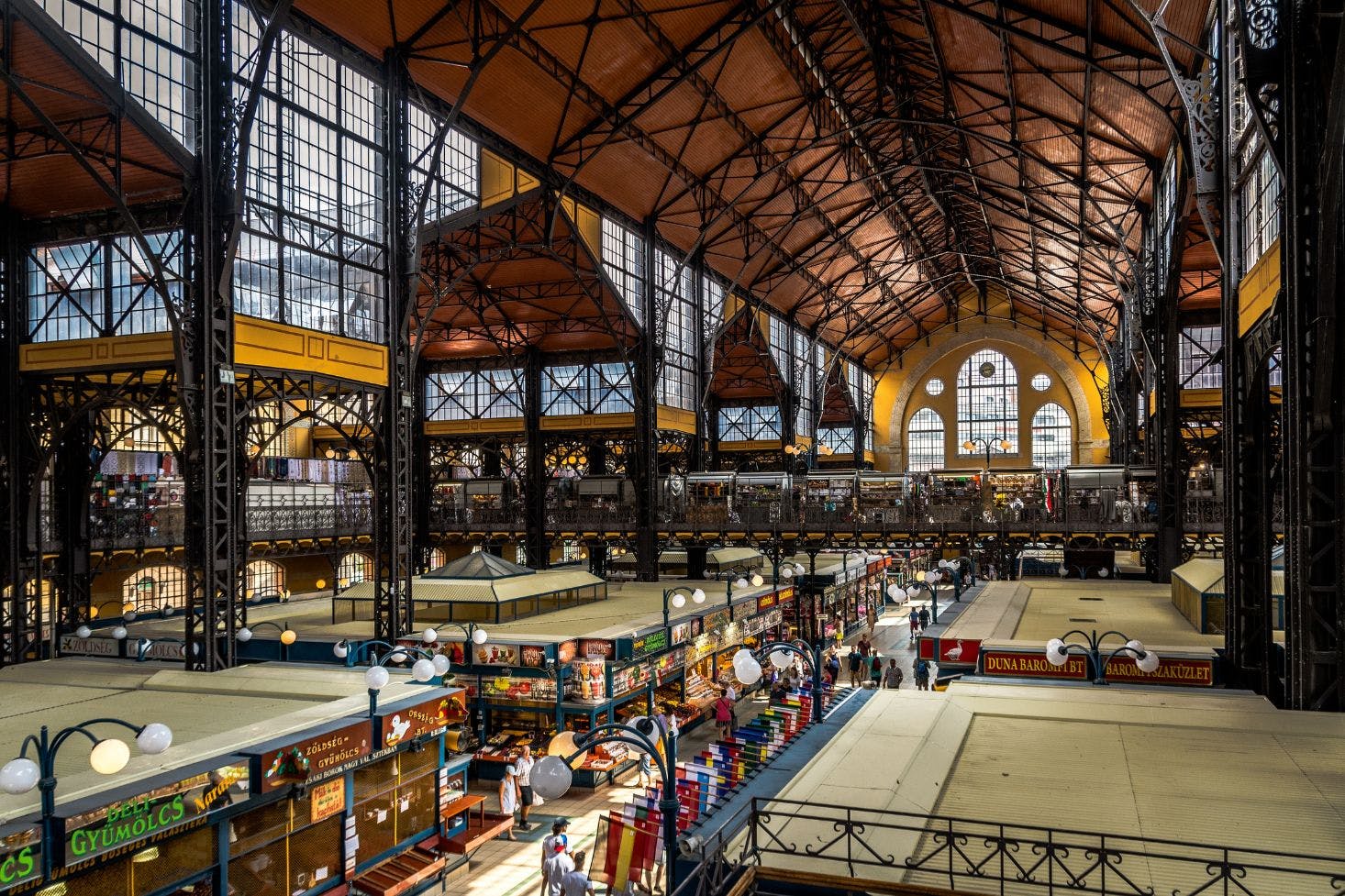 Budapest's Great Market Hall with two floors of stands and shops, plus a large window showcasing a clock