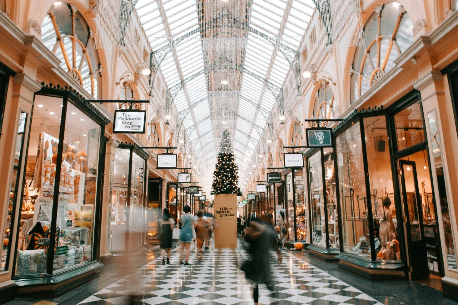 Block Arcade in Melbourne with checkered floors, Christmas decorations, and shoppers walking quickly through the mall