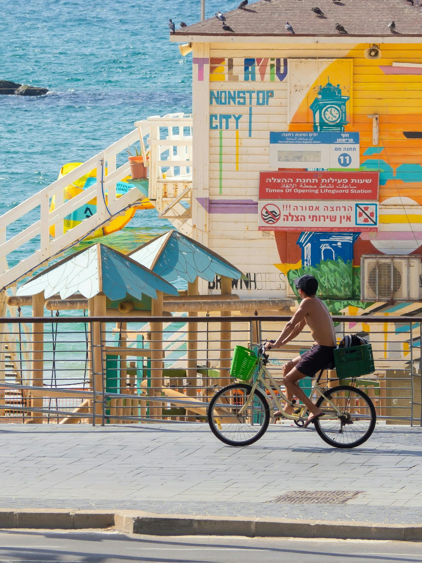 Un garçon à vélo observant une fresque colorée à Tel Aviv, Israel