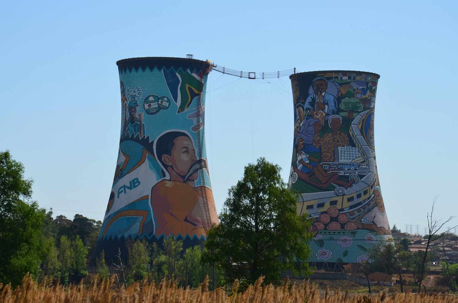 Two cooling towers painted with murals in the Soweto neighborhood of Johannesburg