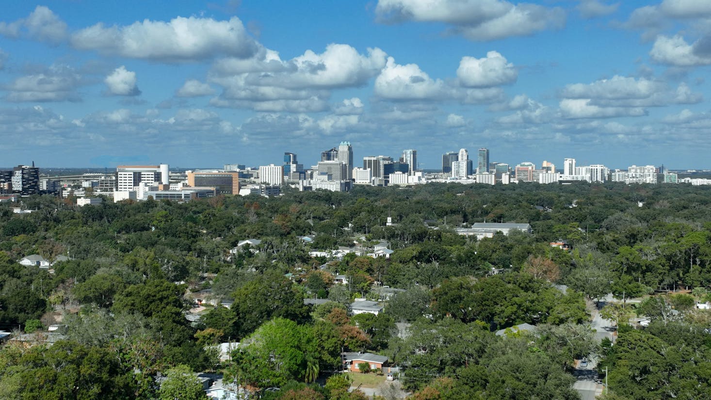 Downtown Orlando in the distance with many green trees in the foreground