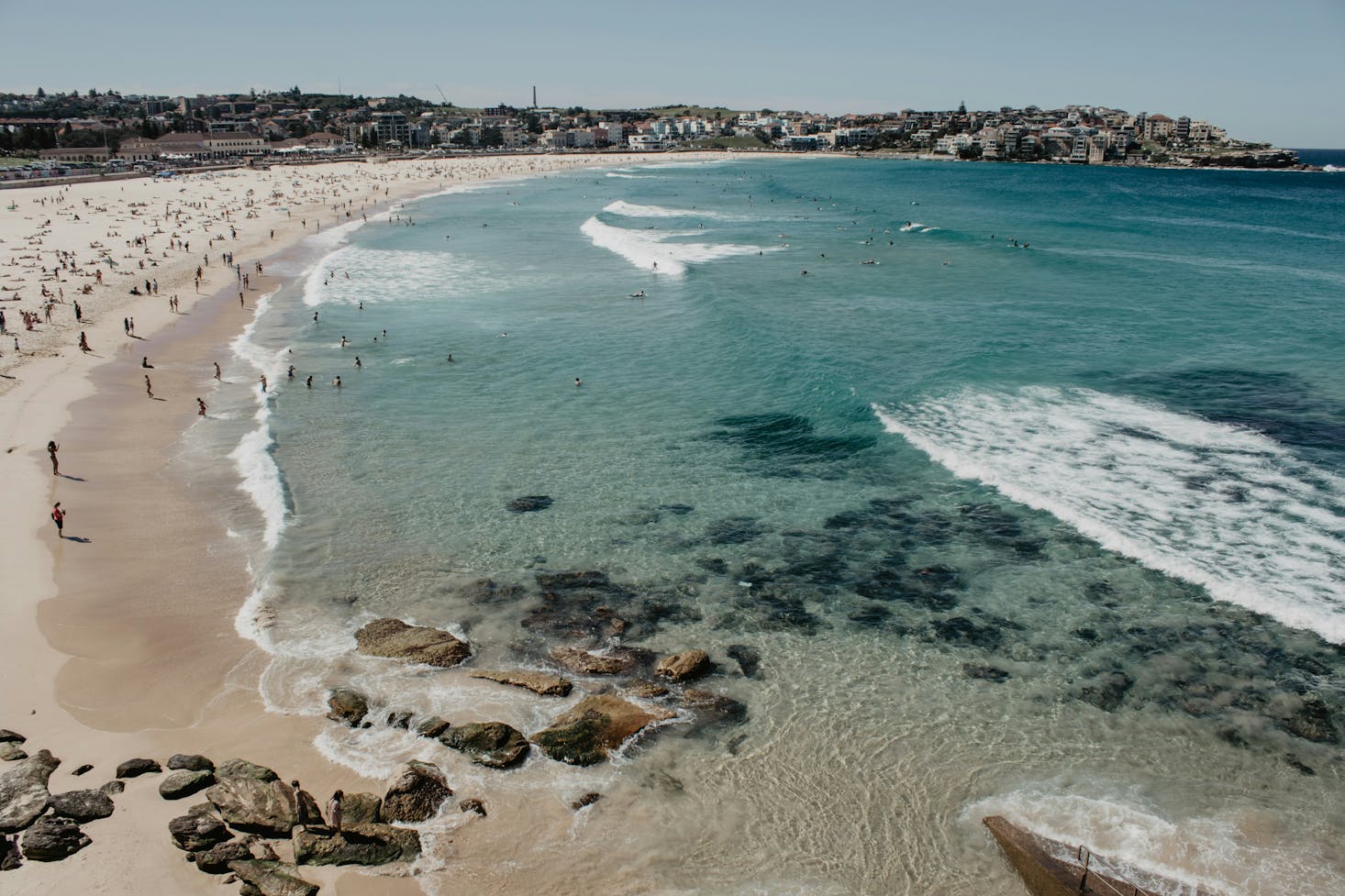 The clear waters of Bondi Beach with people scattered along the shore