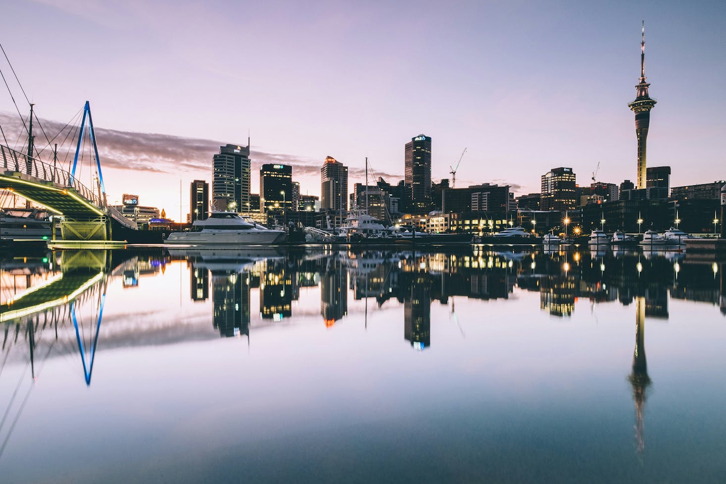 Calm water with a perfect tower and city reflection in Auckland at dusk