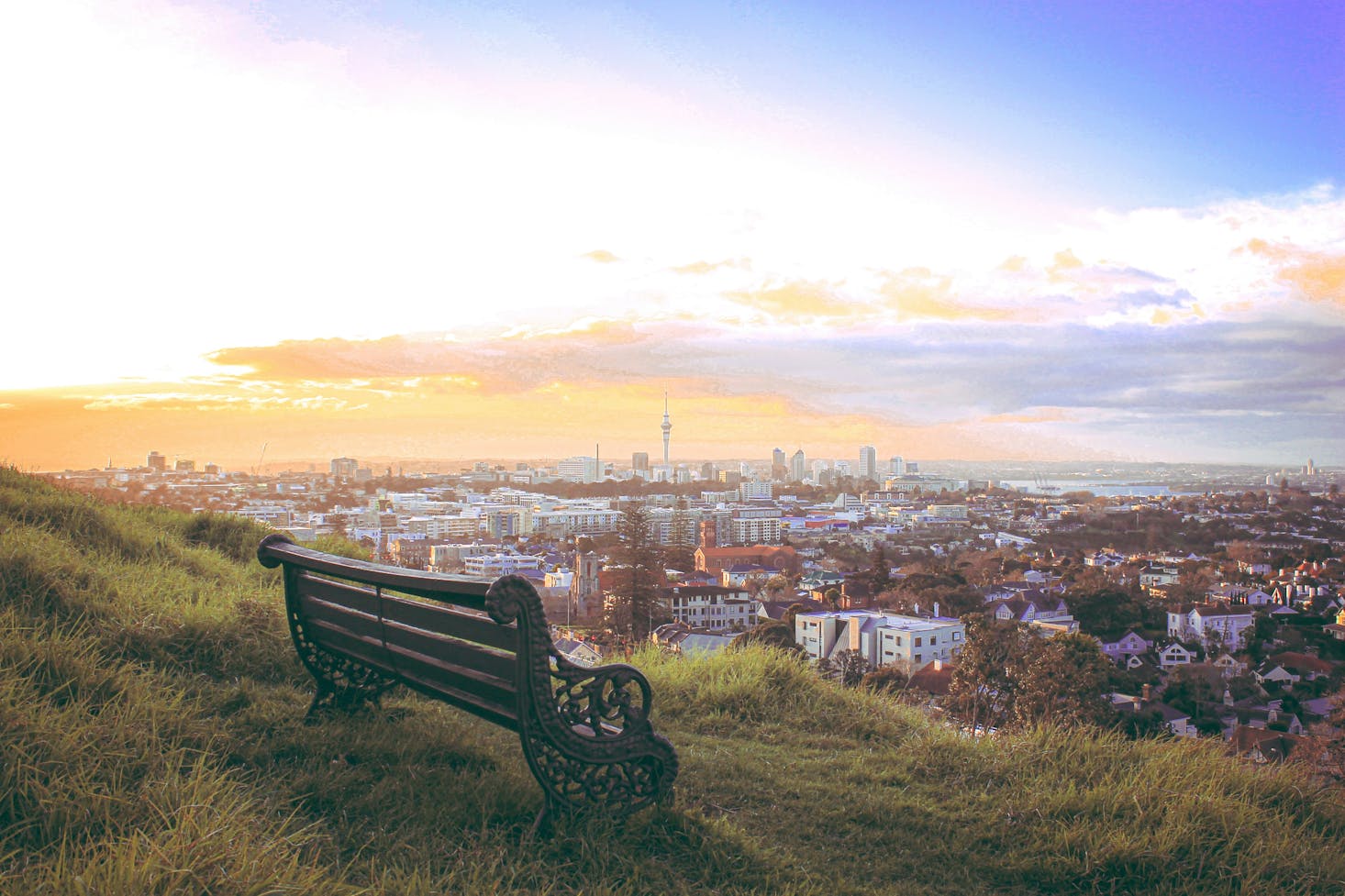 An empty bench on Mount Eden with a sprawling view of Auckland