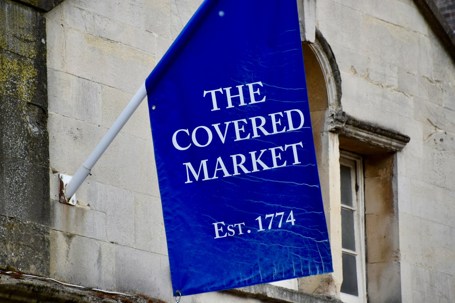 A blue flag with a sign for the Oxford Covered Market