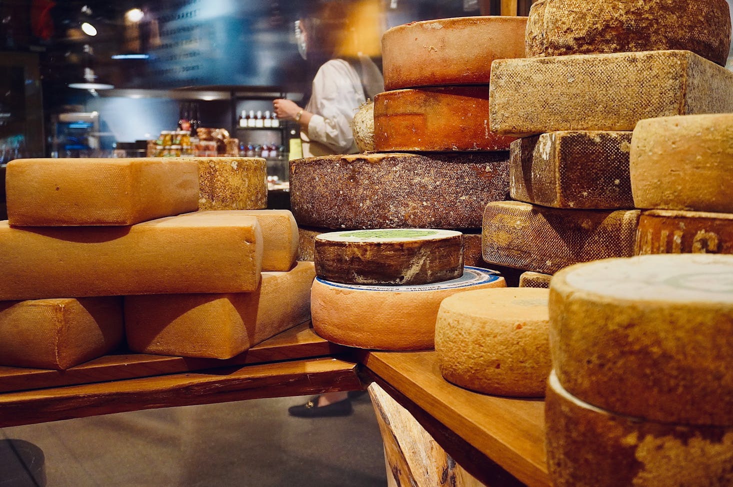 Multiple wheels of cheese piled on a table in Geneva