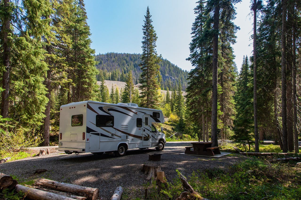 Beautiful campsite in the mountains with an RV and wooden bench